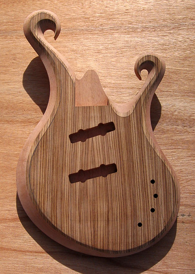 Zebrawood custom bass body with carved dual scrolls