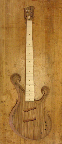 5 string custom bass with maple fretboard, zebrawood top, double scrolls