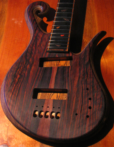 Front of the custom 5 string bass guitar after the first coat of Teak oil, flame figure can be seen on the macassar ebony