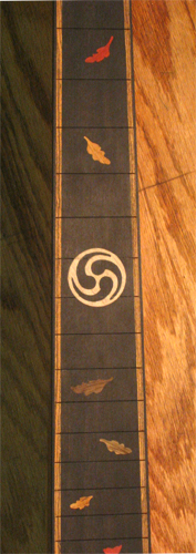 Closeup of ebony fretboard with leaf inlays at positions 7-21