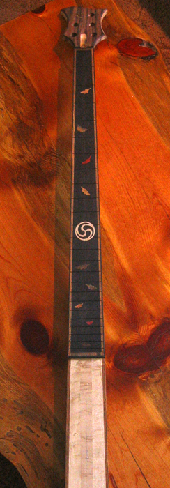 Ebony fretboard with fall-colored leaf inlays and a maple "knot" design