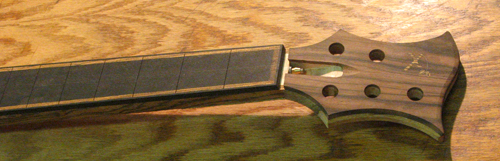 The macassar ebony veneered headstock, ebony bound fretboard and bocote stringers of the custom bass neck