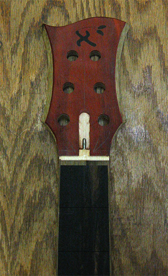 6 string bass headstock with Xylem logo inlay