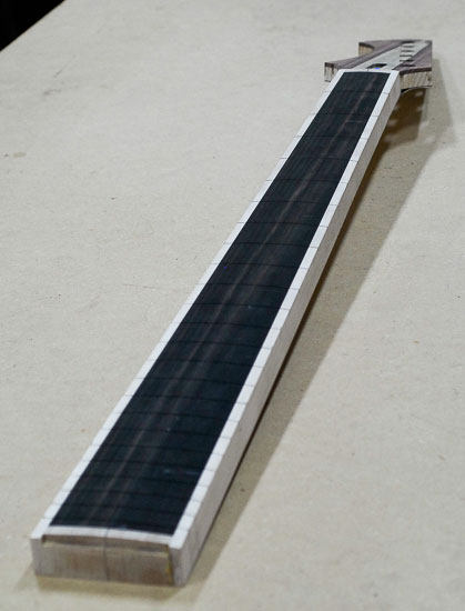 Compound radius on an ebony fretboard of a six-string bass neck