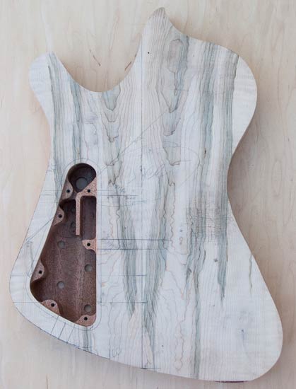 Custom bass body made of mahogany with mineral-stained maple tops, back
