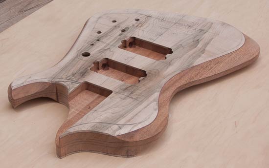 Custom bass body made of mahogany and maple with purpleheart accents