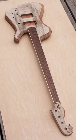 Electric bass guitar with reverse-inline headstock