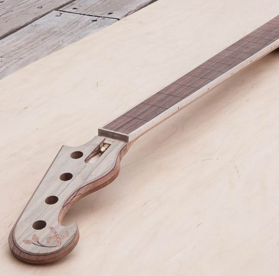 Mineral-stained maple headstock on a bass guitar neck