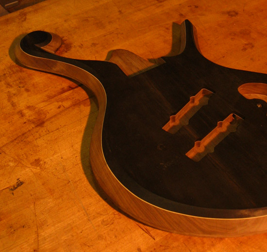Carved arm bevel on a custom bass with an ebony top