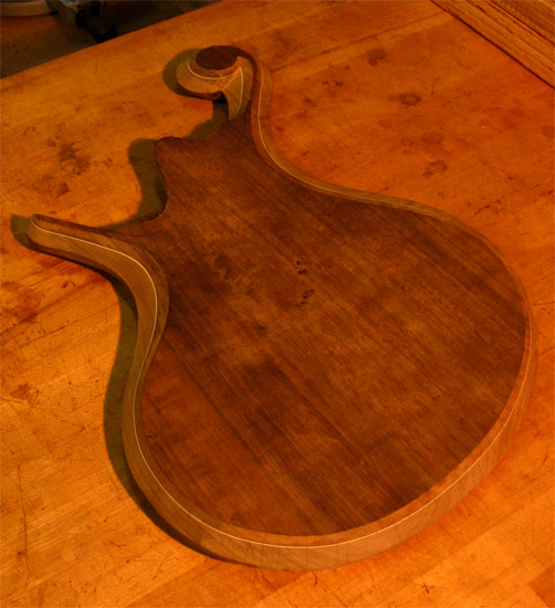 Body bevels on back of a custom bass with black walnut top
