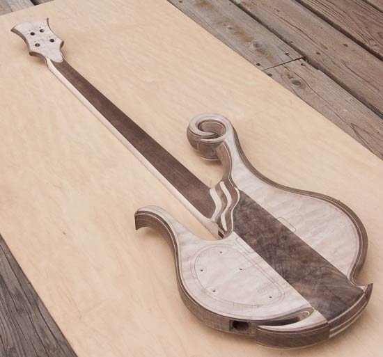 Neck-thru bass guitar with quilted maple tops, walnut accents