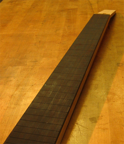 Slotted ebony fretboard on a 6 string bass neck