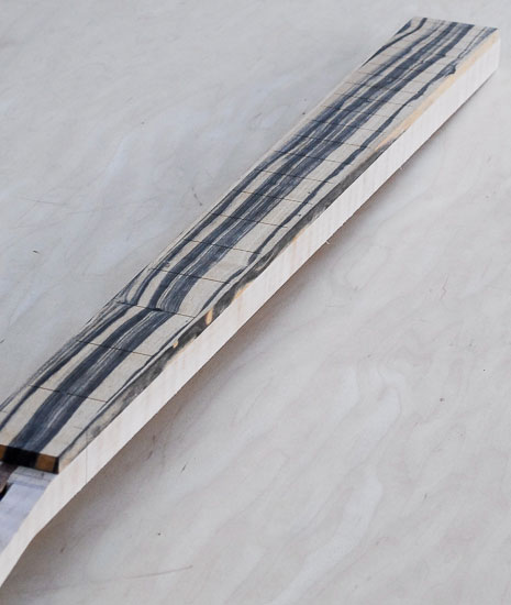 Custom bass neck with ebony fretboard and bloodwood headstock cap