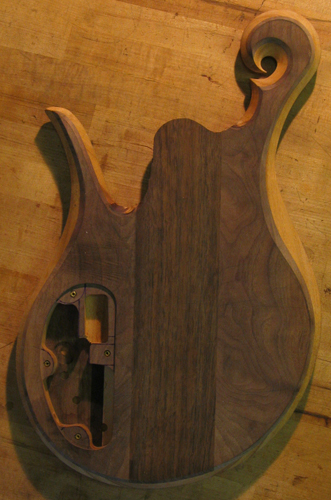 Back of a Xylem 5 string bass after carving with book matched black walnut top wood