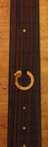 Fretboard inlay of an Uroboros in a Xylem custom bass