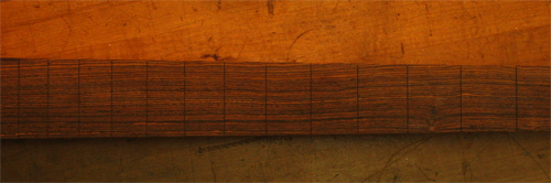 Slotted bocote fretboard of a 4 string custom bass