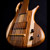 Front of the custom 6 string bass body showing the bridge, pickup cover, and striped body