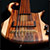 The custom bass body at a low angle showing string thru holes, bridge, pickup and fingerboard
