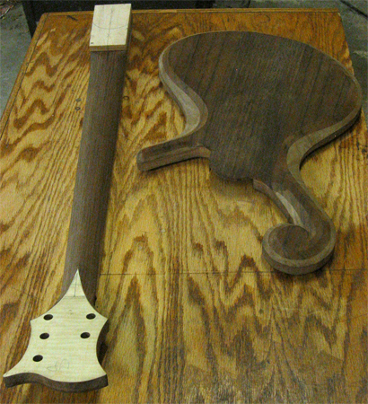 The back of the body and neck of the bass. The black walnut of the body matches that of the neck