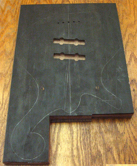 Bass body with pickup pockets routed, string thru holes drilled and outline traced