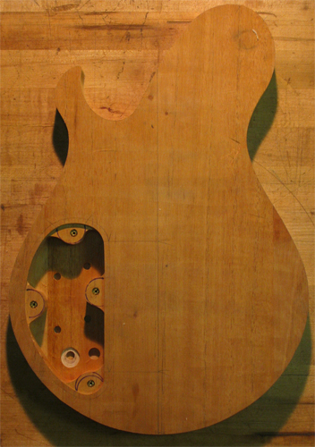 Back of a Xylem guitar body right after cutting out the body shape. Mahogany core and control cavity can be seen