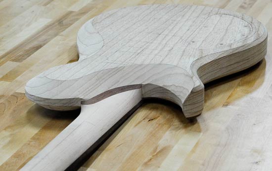 Carved neck heel of a custom guitar build
